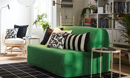 Stue med grønn sofa og puter med grafiske mønstre