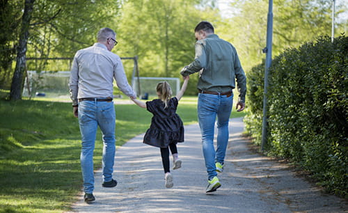 Familie på tur i en park med ryggen til