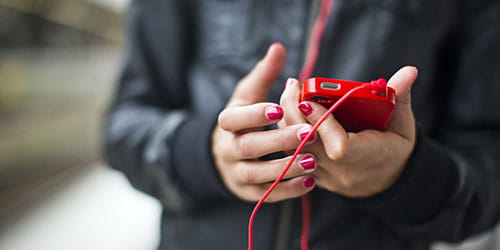 Person med rød telefon og røde hodetelefoner