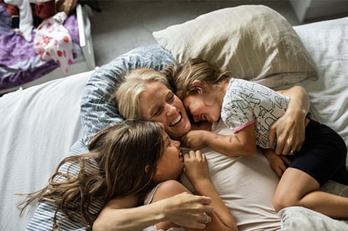 Mor som gir sine to døtre en klem